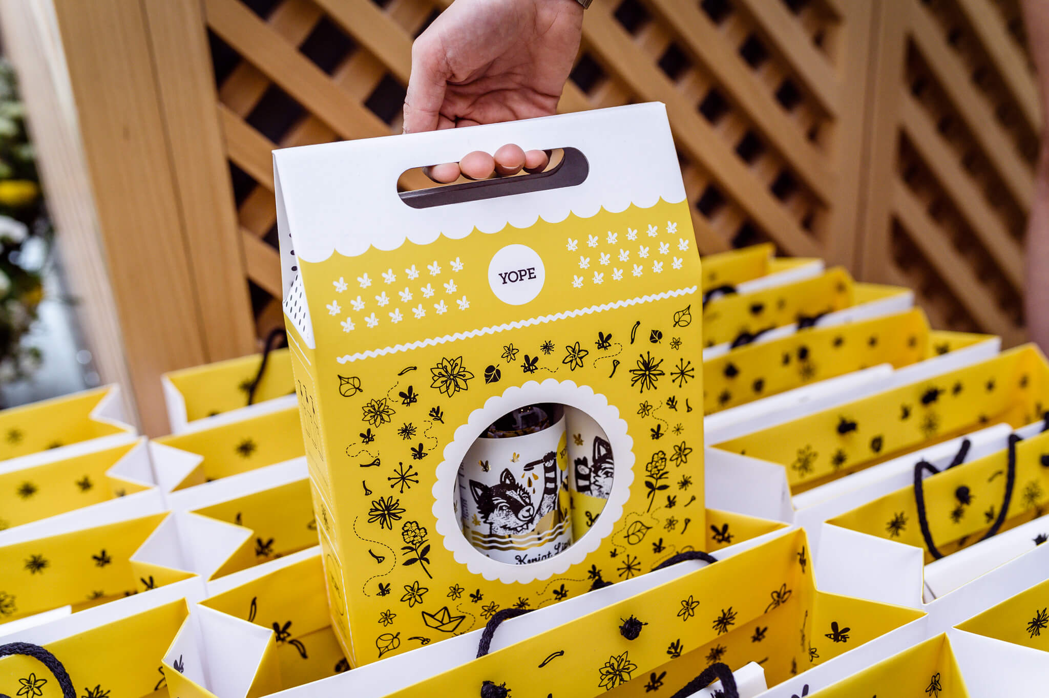 custom die-cut yellow packaging box with decorative patterns and a window cutout